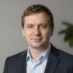 Портрет уверенного российского бизнесмена с дружелюбным взглядом на размытом нейтральном фоне студии