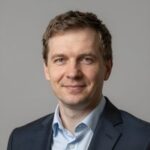 Портрет уверенного российского бизнесмена с дружелюбным взглядом на размытом нейтральном фоне студии